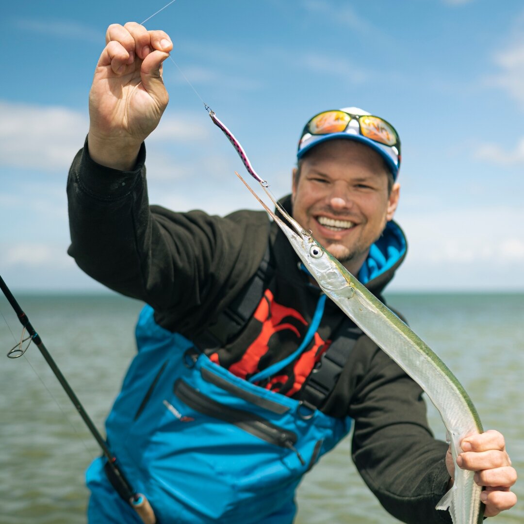 Mann Angler am lächeln Fisch in der Hand 
