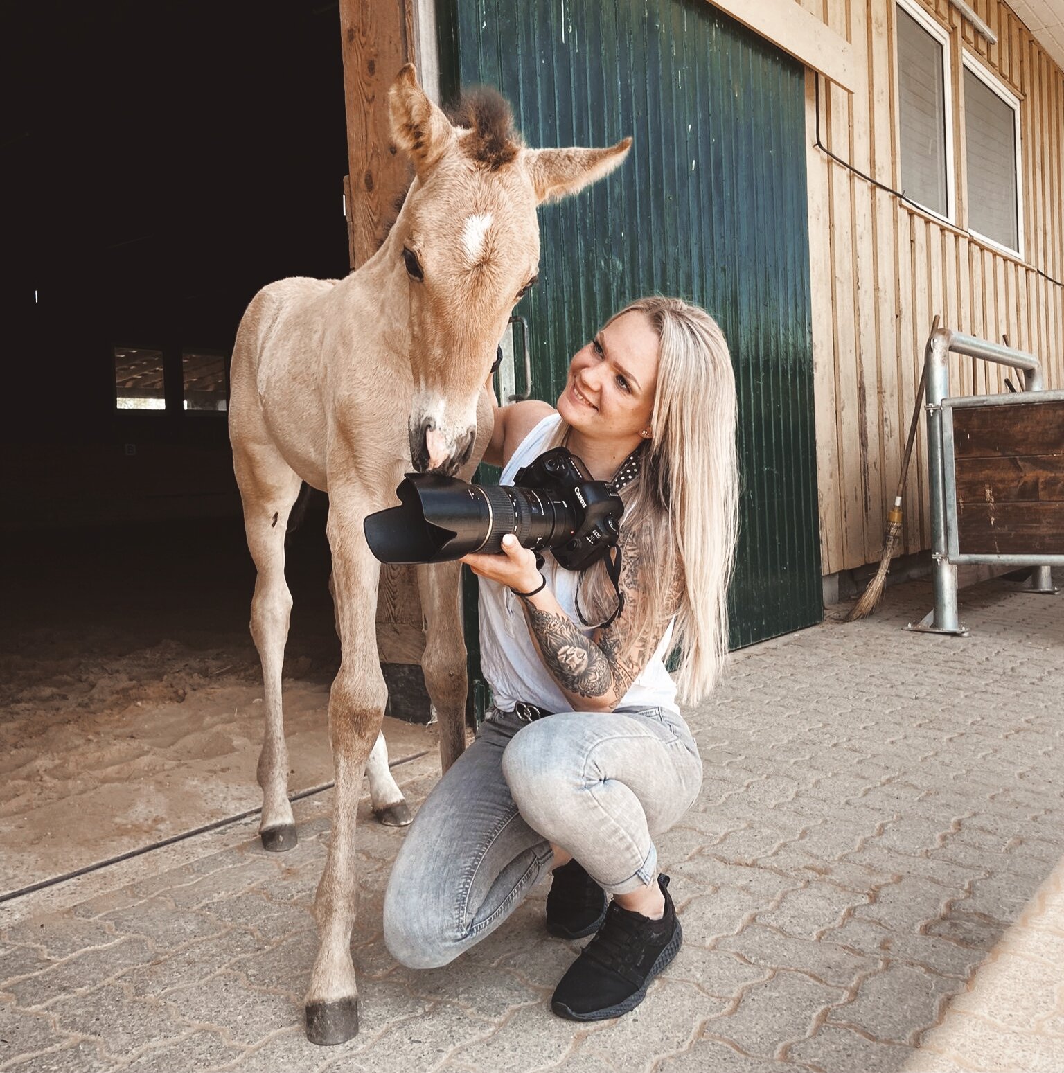 Fotografin Frau mit Kamera mit hellbraunem Fohlen