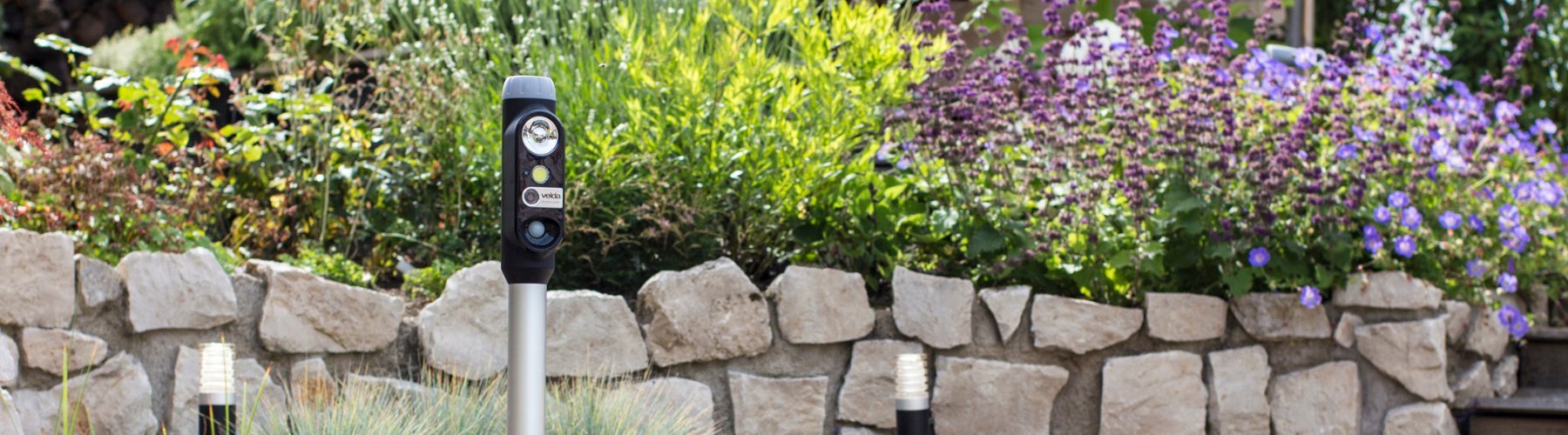 Velda Laser Guard vor einer Steinwand im Garten